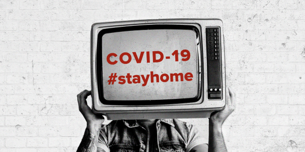 Man holding vintage TV with COVID-19 text label
