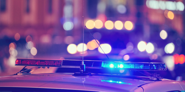 Police car at night with city lights in the background