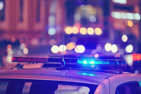 Police car at night with city lights in the background