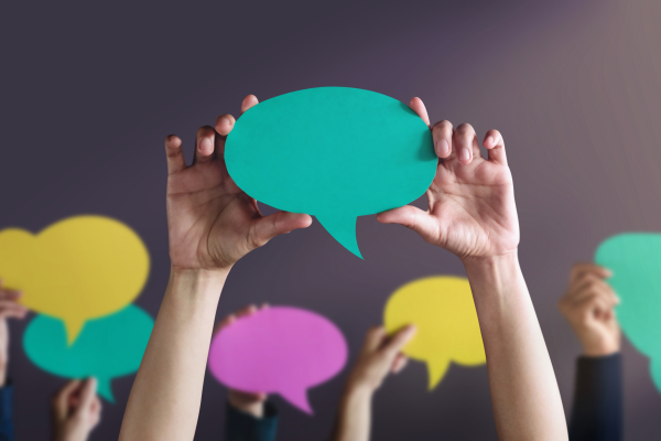 hands holding paper speech bubbles